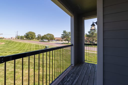 A private balcony at Hawthorne Apartment Homes with a view of the community.